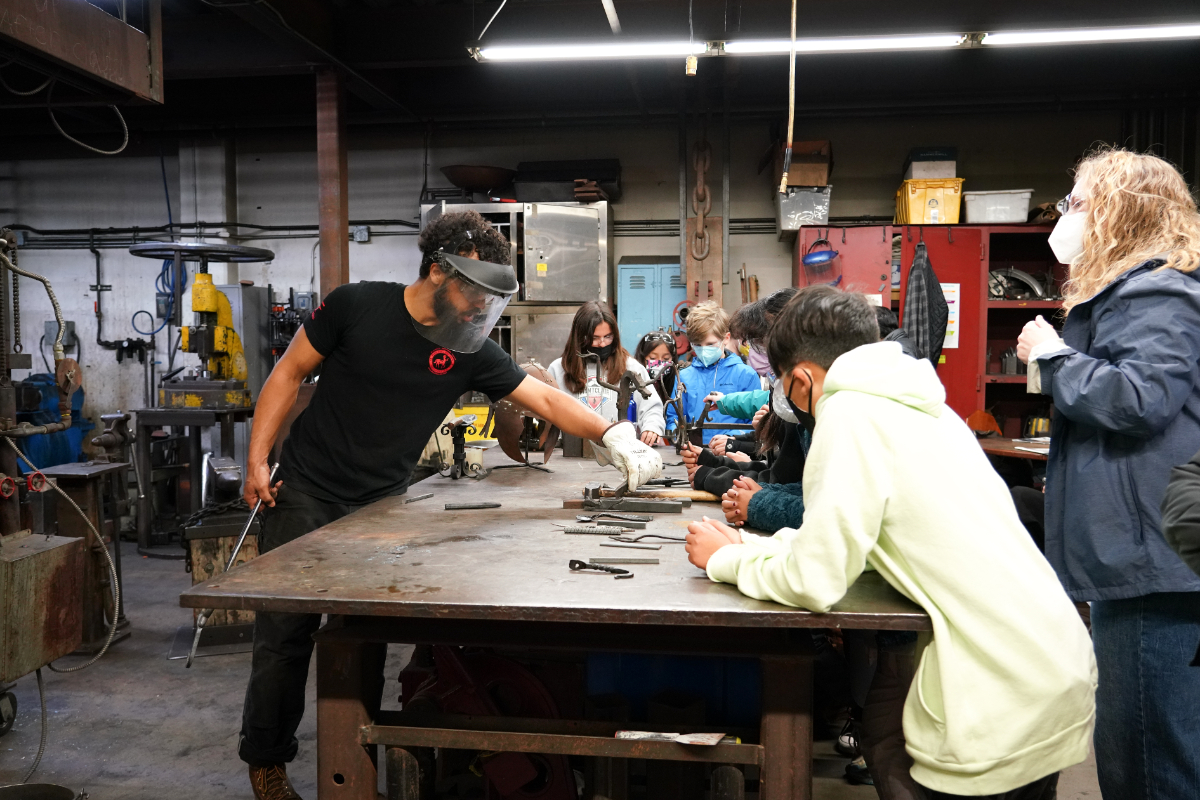 Youth Programs_Field Trip Day_February 23 2023-6575 Youth students watch a blacksmithing demo during a Crucible field trip